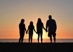family standing in the sunset