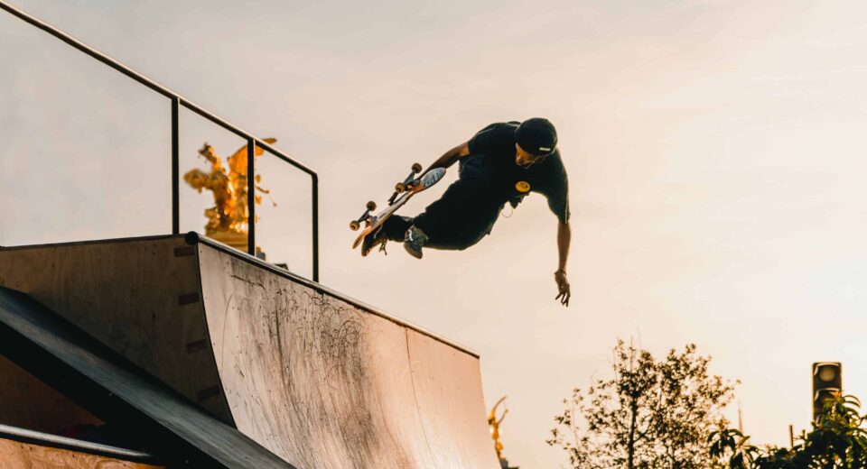 A Skateboarder gains momentum on a half-pipe as he does in aerial trick.